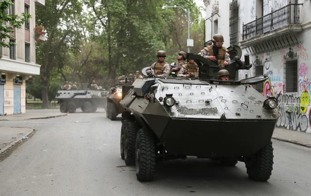 Soldiers ride an armoured transporter as they patrol a street after a previous day's protest against the increase in subway ticket prices in Santiago, Chile, October 20, 2019. REUTERS/Ivan Alvarado