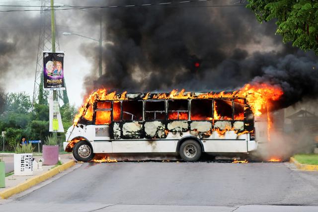 FILE PHOTO: A burning bus, set alight by cartel gunmen to block a road, is pictured during clashes with federal forces following the detention of Ovidio Guzman, son of drug kingpin Joaquin El Chapo Guzman, in Culiacan, Sinaloa state, Mexico October 17, 2019. REUTERS/Jesus Bustamante 