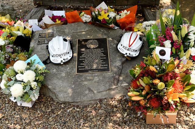 Flowers and the helmets of volunteer firefighters Andrew O'Dwyer and Geoffrey Keaton, who died when their fire truck was struck by a falling tree as it traveled through the front line of a fire, are seen at a memorial at the Horsley Park Rural Fire Brigade in Horsley Park, NSW, December 20, 2019. AAP Image/Bianca De Marchi/via REUTERS
