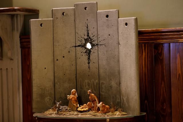 An artwork dubbed scar of Bethlehem by street artist Banksy is displayed in the Walled Off hotel, in Bethlehem in the Israeli-occupied West Bank December 22, 2019. REUTERS/Mussa Qawasma