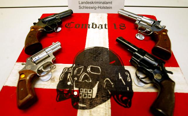 FILE PHOTO: Confiscated guns and Neo Nazi propaganda material is displayed during a news conference at a police station in the northern German Baltic Sea coastal town of Kiel October 28, 2003. REUTERS/Christian Charisius REUTERS/File Photo
