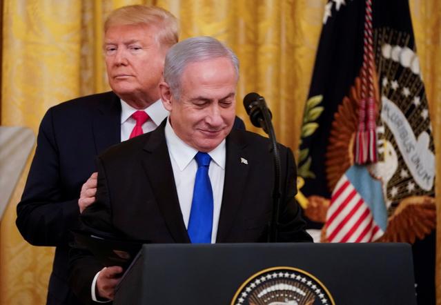 FILE PHOTO: U.S. President Donald Trump puts his hands on Israel's Prime Minister Benjamin Netanyahu's shoulders as they deliver joint remarks on a Middle East peace plan proposal in the East Room of the White House in Washington, U.S., January 28, 2020. REUTERS/Joshua Roberts