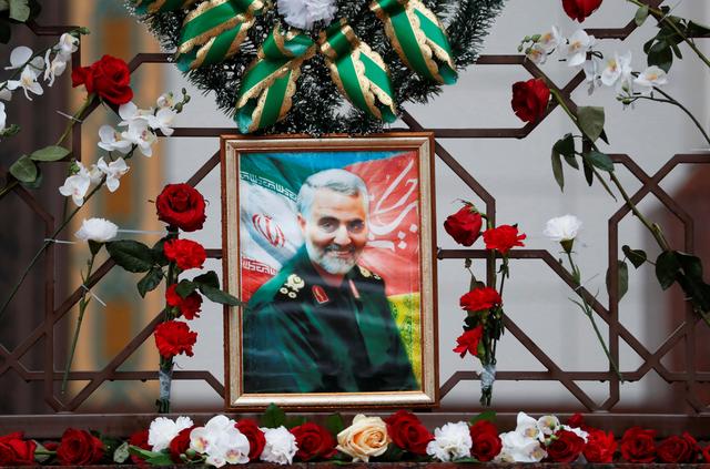 FILE PHOTO: Flowers lie around a portrait of Iranian Major-General Qassem Soleimani, who was killed in an airstrike near Baghdad, at the Iranian embassy's fence in Minsk, Belarus January 10, 2020. REUTERS/Vasily Fedosenko