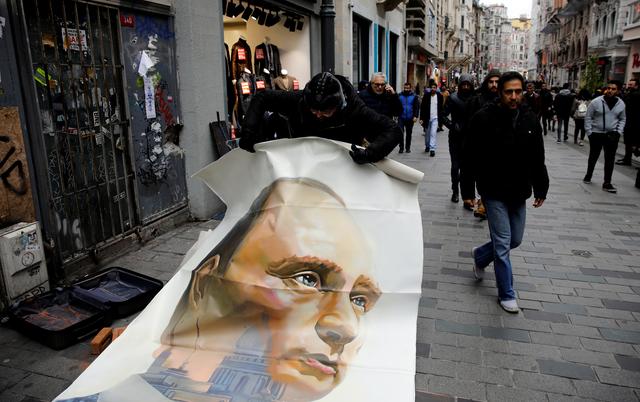 Russian artist and former mayor of Arkhangelsk Alexander Donskoy picks up a portrait of Russian President Vladimir Putin at Istiklal Street in Istanbul, Turkey February 15, 2020. REUTERS/Umit Bektas