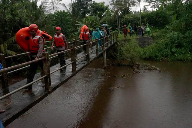 Rescue workers walk past a bridge as they search for students who were missing after a tidal surge swept them away during a school trip, in Sleman, Yogyakarta, Indonesia, February 21, 2020 in this photo taken by Antara Foto. Antara Foto/Andreas Fitri Atmoko/via REUTERS  ATTENTION EDITORS - THIS IMAGE WAS PROVIDED BY A THIRD PARTY. MANDATORY CREDIT. INDONESIA OUT.