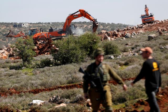 Israeli machineries, guarded by Israeli forces, bulldoze lands near the Palestinian village of Qusra, in the Israeli occupied West Bank, March 3, 2020. REUTERS/Mohamad Torokman
