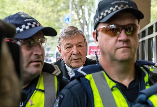 FILE PHOTO: Vatican Treasurer Cardinal George Pell walks towards the Melbourne Magistrates Court with Australian police in Australia, October 6, 2017.    REUTERS/Mark Dadswell