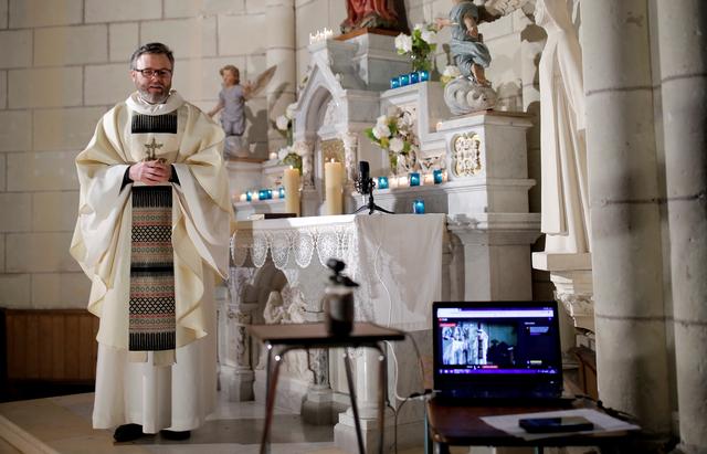 French priest Guillaume Le Floc'h conducts a mass streamed online on the feast of the Annunciation at the church in Carquefou near Nantes as a lockdown is imposed to slow the rate of the coronavirus disease (COVID-19) spread in France, March 25, 2020. REUTERS/Stephane Mahe   