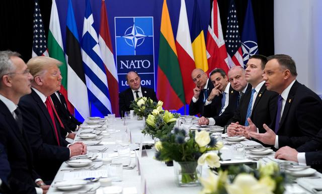 FILE PHOTO: NATO Secretary General Jens Stoltenberg looks on as U.S. President Donald Trump and Poland's President Andrzej Duda talk during a working lunch during the NATO leaders summit in Watford, Britain, December 4, 2019. REUTERS/Kevin Lamarque/File Photo