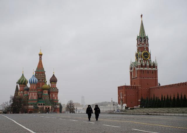 FILE PHOTO: Police officers walk along the Red Square, with St. Basil's Cathedral and the Kremlin's Spasskaya Tower in the background, after the city authorities announced a partial lockdown ordering residents to stay at home to prevent the spread of coronavirus disease (COVID-19), in central Moscow, Russia March 30, 2020. REUTERS/Alexandra Anikeeva