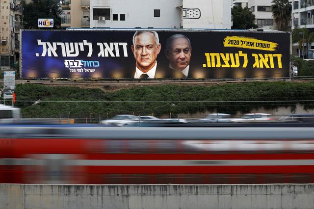 FILE PHOTO: Traffic moves past a Blue and White party election campaign poster, depicting party leader Benny Gantz, and Israeli Prime Minister Benjamin Netanyahu, in Tel Aviv, Israel February 18, 2020. REUTERS/Amir Cohen/File Photo